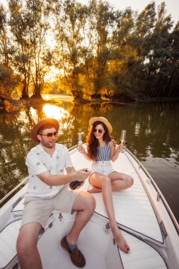 Güzel, genç bir çift yaz tatilinin tadını çıkarıyorlar. Bir şişe şampanya açıp yıldönümünü kutluyorlar. Gün batımına yelken açıyorlar.