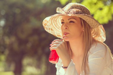 Suyu içme güneşli bir günde parkta güzel bir genç kadın portresi