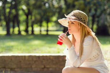 Suyu içme güneşli bir günde parkta güzel bir genç kadın portresi