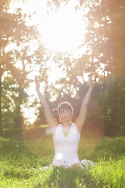 Orta yaşlı kadın Yoga sabah erken bir parkta yapıyor.
