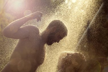 Genç çift yüzdükten sonra sahilde duş alıyor.