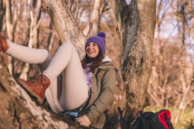 Aktif genç bir kadın, sonbahar gününü ormanda geçirir, yürüyüş yapar ve sonbahar macerasının tadını çıkarır.