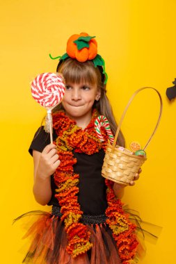 Cadı kostümlü küçük kız Cadılar Bayramı 'nda şeker toplarken eğleniyor.