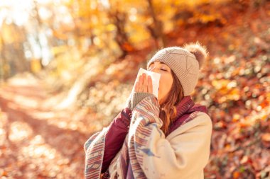 Kadın soğuk aldı, güneşli bir sonbahar gününü dışarıda geçirirken burnunu sümkürdü.