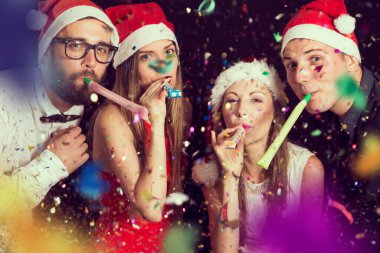 İki güzel genç çift yeni yıl partisinde eğleniyor, dans ediyor ve parti düdüğü çalıyorlar.