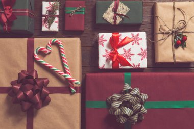 Tahta masanın üzerinde duran güzel paketlenmiş Noel hediyelerinin üst görüntüsü.