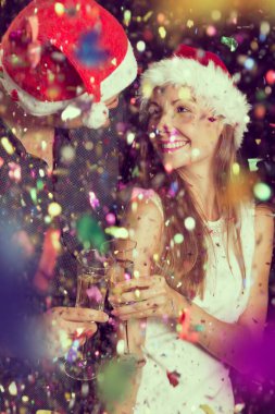 Genç ve güzel bir çift bir partide eğleniyor, ellerinde şampanya bardakları ve kadeh kaldırıyorlar.