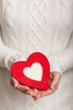 Avucunun içinde kalp şeklinde bir bardak altlığı tutan kadın elleri. Kalbe odaklan.