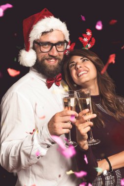 Genç ve güzel bir çift bir partide eğleniyor, ellerinde şampanya bardakları ve kadeh kaldırıyorlar. Adama odaklan.