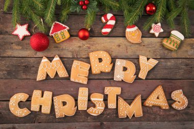 Harf şeklinde renkli zencefilli kurabiye tablosu Köknar ağacı dallarında Mutlu Noeller ve Noel ağacı süslemeleri