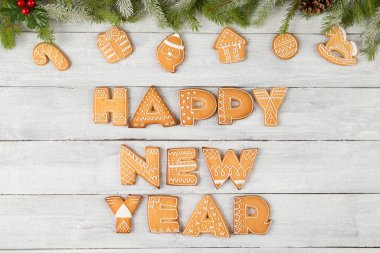 Harf şeklinde zencefilli kurabiye tablosu. Yeni yılınız kutlu olsun. Birkaç köknar dalı, kozalak ve ökseotu.