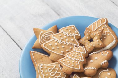 Güzel dekore edilmiş Noel kurabiyelerini tabağa koy. Seçici odak