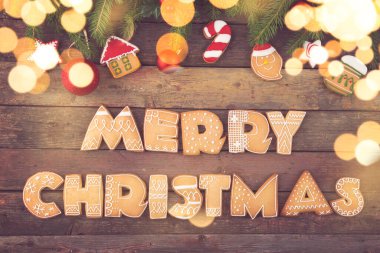 Harf şeklinde renkli zencefilli kurabiye tablosu Köknar ağacı dallarında Mutlu Noeller ve Noel ağacı süslemeleri