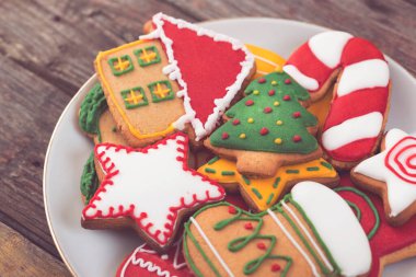Renkli, güzel dekore edilmiş Noel kurabiyelerini tabağa koy. Seçici odak