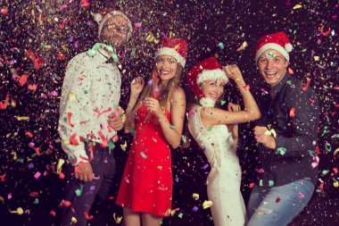 Yılbaşı partisinde Noel Baba şapkası takıp dans eden iki güzel genç çift.