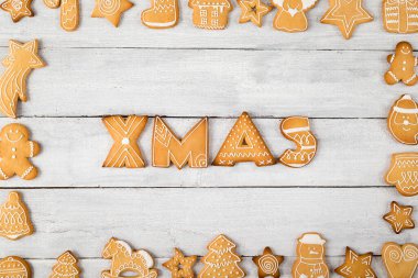 Çerçevesinde Xmas yazan güzel dekore edilmiş zencefilli kurabiyelerden yapılmış bir çerçevenin masa üstü resmi.