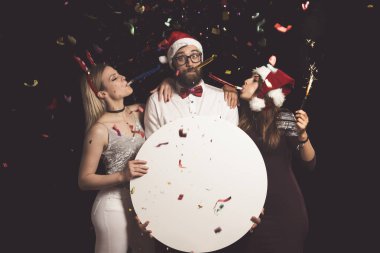 Bir grup arkadaş eğleniyor, yeni yıl arifesini kutluyorlar ve boş bir mukavva çemberi tutuyorlar.