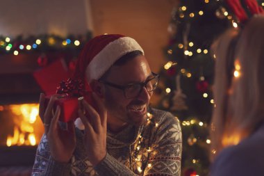 Birbirlerine aşık genç bir çift şöminenin yanında oturmuş Noel ağacını süslüyor ve Noel hediyelerini değiş tokuş ediyorlardı.