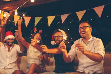 Arkadaşlar dışarıda yeni yıl partisinde eğleniyorlar, dans ediyorlar, şarkı söylüyorlar ve gece yarısı havai fişeklerle el sallıyorlar.