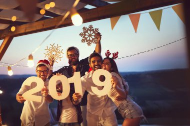 Bir grup genç arkadaş yeni yıl havuz partisinde eğleniyorlar, dans ediyorlar ve karton kar taneleri tutuyorlar ve 2019 numara. Sağdaki çifte odaklan.
