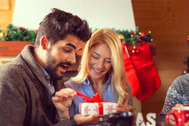 Çiftler Noel 'i evde kutlarken, Noel hediyelerini alırken eğleniyorlar.