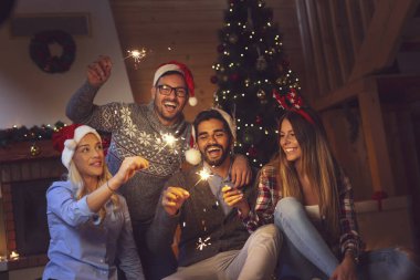 Bir grup genç arkadaş yılbaşı kutlamasında eğleniyor, gece yarısı geri sayımında maytap tutuyorlar.