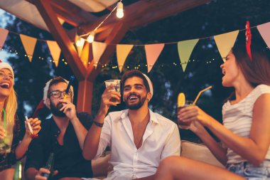 Bir grup arkadaş parti düdüğü çalıyor, bira içiyor ve yeni yıl partisinde eğleniyorlar.