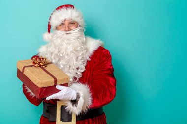 Noel Baba 'nın portresi güzelce paketlenmiş bir Noel hediyesi. Nane rengi arka planda izole edilmiş ve fotokopi alanı olan.