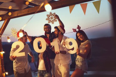 Bir grup genç arkadaş yeni yıl havuz partisinde eğleniyorlar, dans ediyorlar ve karton kar taneleri tutuyorlar ve 2019 numara. Ortadaki adamlara odaklan.