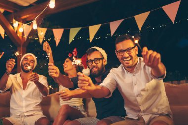 Arkadaşlar yılbaşı partisinde eğleniyorlar, dans ediyorlar, içiyorlar ve gece yarısı havai fişeklerle el sallıyorlar.