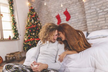 Güzel, birbirine aşık genç bir çift Noel sabahı uyandıktan sonra sarılıp sarılıyor, kahve içiyor ve birlikte vakit geçiriyorlar.