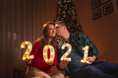 Öpüşen çift, Covid 19 salgın önleme tedbirlerinin bir parçası olarak sosyal uzaklık nedeniyle 2021 yılını evde kutluyor.