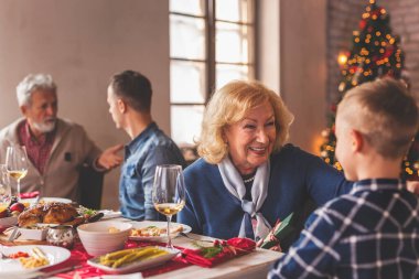 Mutlu bir aile Noel 'i kutluyor, evde yemek yiyor ve birlikte vakit geçiriyorlar. Büyükannem torununa Noel hediyesi veriyor.