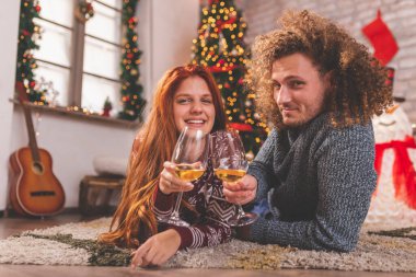 Güzel, genç ve aşık bir çift Noel 'i evde birlikte geçirir. Şarap kadehlerini kaldırır, kadeh kaldırır.