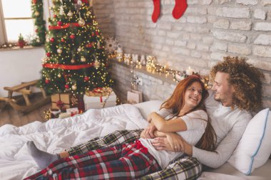 Güzel, genç ve aşık bir çift Noel sabahı yatakta yatar, sarılır, kucaklaşır ve kış tatili boyunca birlikte vakit geçirirler.