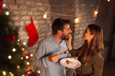 Güzel, birbirine aşık genç bir çift Noel ağacının yanında duruyor, Noel arifesinde kokteyl partisinde eğleniyorlar.