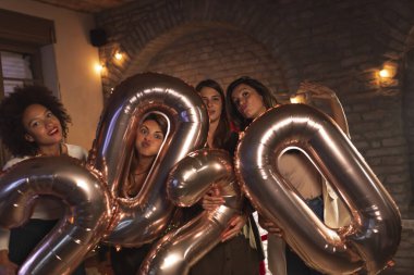 Yeni yıl arifesini birlikte kutlayan bir grup kadın, 2020 numaralı dev balonları ellerinde tutarak yaklaşan yeni yılı temsil ediyorlar.