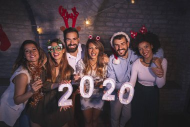 Yeni yıl partisinde eğlenen bir grup arkadaş, 2020 yılını gece yarısı geri sayımını temsil ediyor.