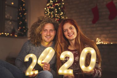 Güzel, genç ve aşık bir çift yeni yıl arifesini evde kutlarken 2020 yılını temsil ediyor.