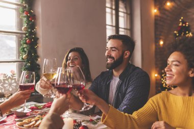 Arkadaşlar Noel yemeğinde kadeh kaldırıyor, kadeh kaldırıyor, kutlama yapıyor ve kış tatillerini birlikte geçiriyorlar.
