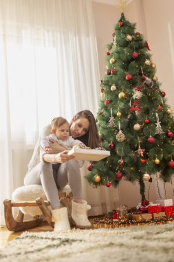 Anne ve oğlu Noel günü evde eğleniyor, Noel ağacı süslüyorlar.