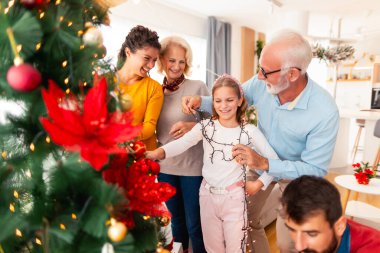 Güzel, mutlu, çok nesilli aile, Noel ağacını süsleyerek kış tatili kutlaması için evlerinde toplandı.