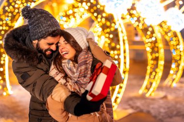 Birbirlerine aşık çiftler Noel arifesini dekore edilmiş şehir sokaklarında geçirirken birbirlerine Noel hediyelerini veriyorlar.