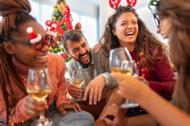 Bir grup genç arkadaş evde birlikte Noel 'i kutlarken şarap içiyor, gülüyor ve eğleniyorlar.