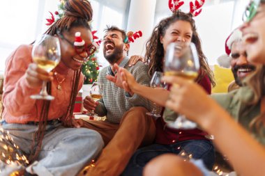 Bir grup genç arkadaş evde birlikte Noel 'i kutlarken şarap içiyor, gülüyor ve eğleniyorlar.