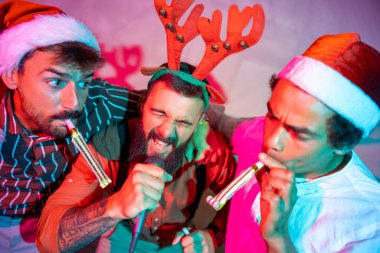 Bir grup neşeli erkek arkadaş yeni yıl partisinde karaoke söyleyip dans ederek eğleniyor.