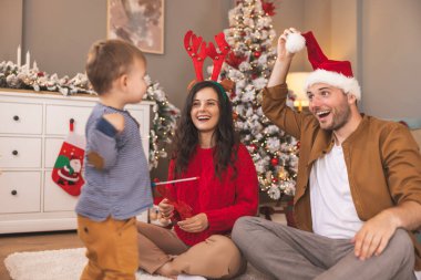 Ebeveynler ve çocuklar Noel 'i evde birlikte geçirip, oynayıp, kış tatilinin tadını çıkarıyorlar.