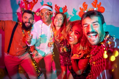 Bir grup neşeli genç arkadaş yeni yıl partisinde selfie çekerken eğleniyorlar.