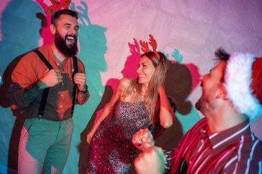 Bir grup neşeli genç arkadaş yeni yıl partisinde dans edip şarkı söylüyor.