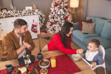 Babam kahve içerken, annem de küçük bebeğini beslerken evde Noel kahvaltısı yapıyor.
